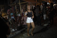 A woman dances during a street performance by the Brazilian band Atitude Nossa as the restrictions related to the COVID-19 pandemic are eased in Rio de Janeiro, Brazil, Monday, Oct. 5, 2020. Since the beginning of October, live shows are now permitted in Rio de Janeiro. (AP Photo/Silvia Izquierdo)