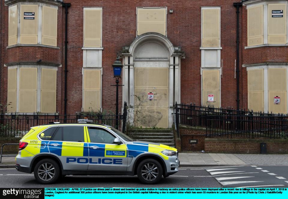 A police car drives past a closed and boarded up police station in Hackney in April 2018 (Getty Images)