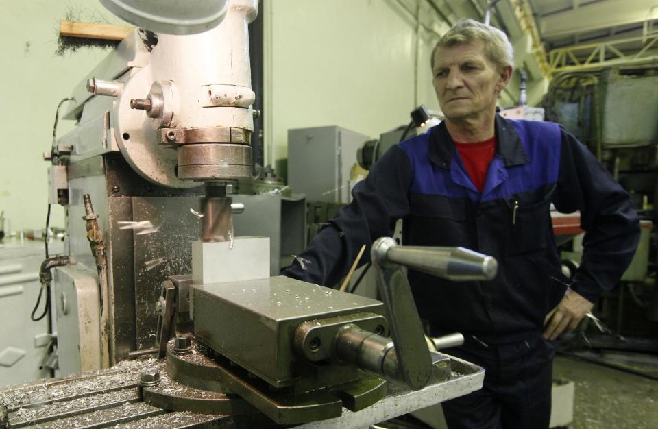 A milling-machine operator produces aluminium details for space satellites at a workshop of the Reshetnev Information Satellite Systems company in Zheleznogorsk