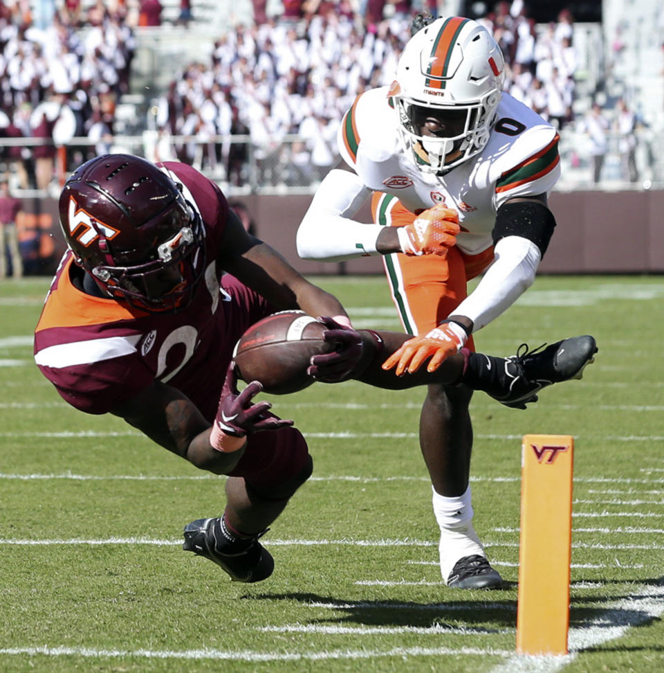 Virginia Tech's Malachi Thomas (24) dives in for a touchdown past Miami's James Williams (0) in the second half of an NCAA football game, Saturday Oct. 15 2022, in Blacksburg Va. (Matt Gentry/The Roanoke Times via AP)