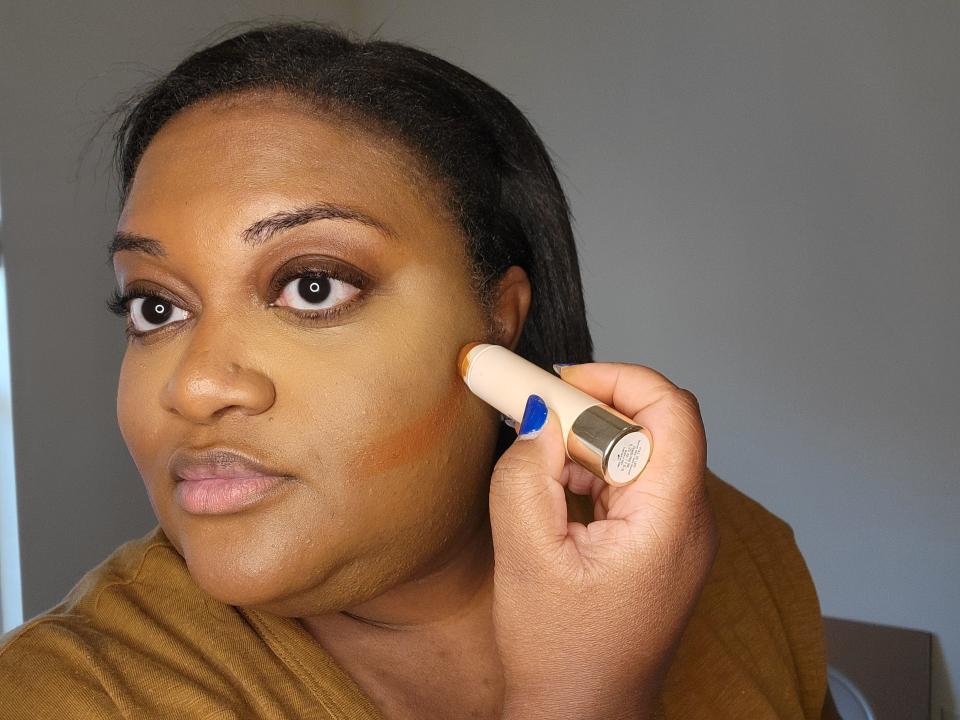 The writer contours her face with a Rare Beauty bronzer