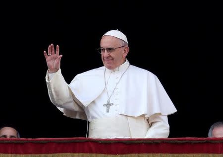 Pope Francis waves as he arrives to leads "Urbi et Orbi" (to the city and the world) message from the balcony overlooking St. Peter's Square at the Vatican December 25, 2016. REUTERS/Alessandro Bianchi