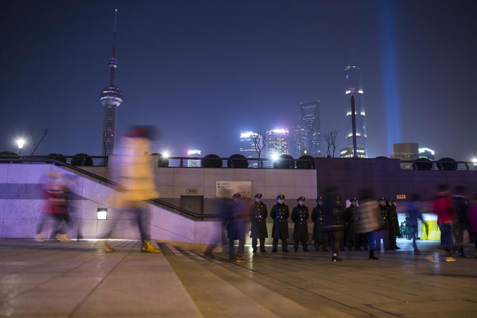 Paramilitary police officers stand guard on the location where people were killed in a stampede incident during a New Year's celebration on the Bund in Shanghai