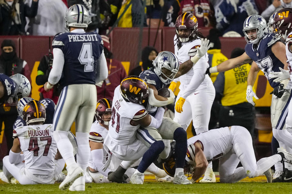 Dallas Cowboys running back Tony Pollard (20) raises his arm while scoring a touchdown against Washington Commanders linebacker Jabril Cox (41) during the first half of an NFL football game, Sunday, Jan. 7, 2024, in Landover, Md. (AP Photo/Susan Walsh)