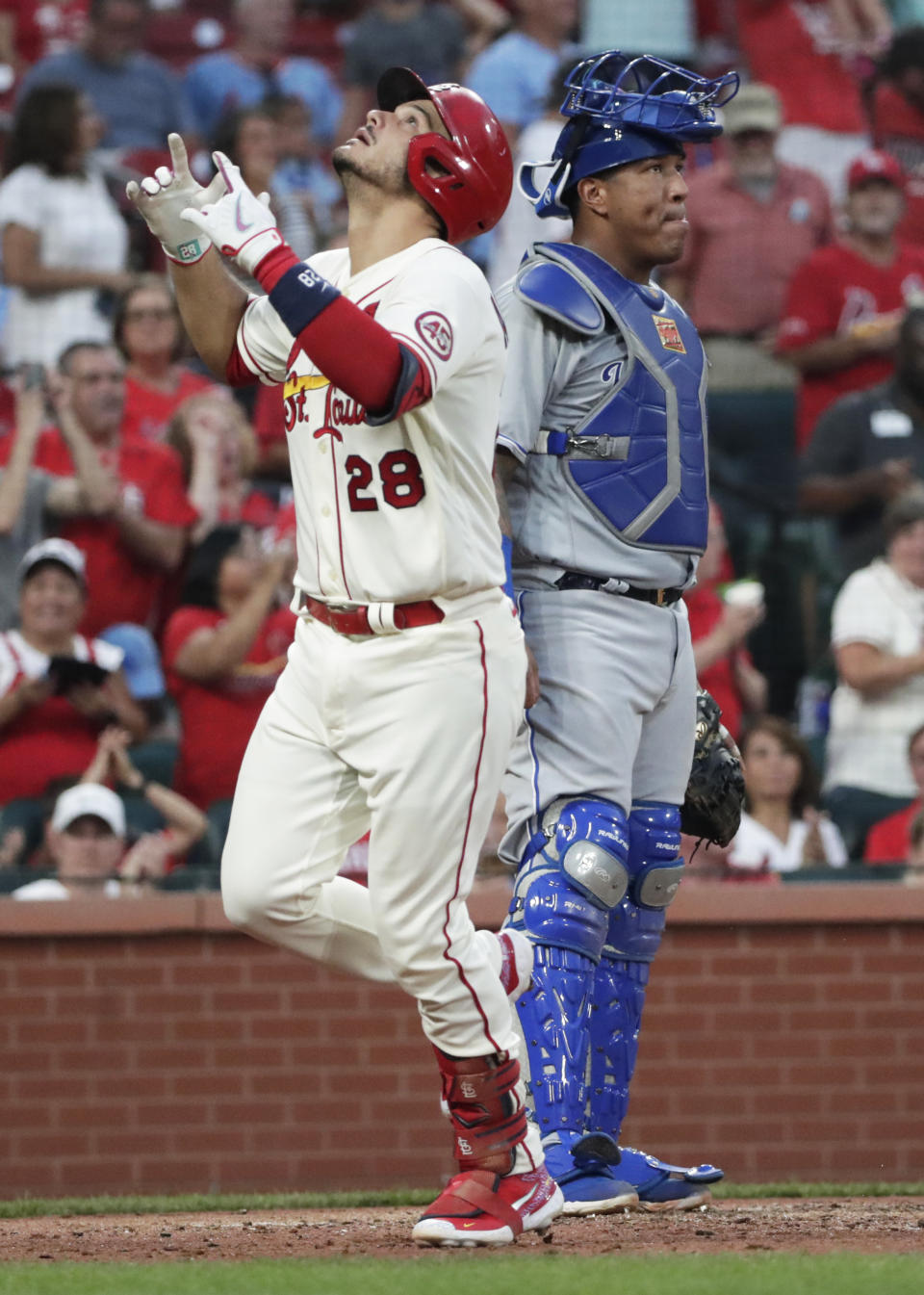 St. Louis Cardinals' Nolan Arenado (28) celebrates as he crosses home plate after hitting a solo home run next to Kansas City Royals catcher Salvador Perez during the fifth inning of a baseball game Saturday, Aug. 7, 2021, in St. Louis. (AP Photo/Tom Gannam)