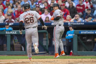San Francisco Giants' Patrick Bailey, right, and Matt Chapman, left come in to score on the double by Thairo Estrada during the second inning of a baseball game against Philadelphia Phillies, Friday, May 3, 2024, in Philadelphia. (AP Photo/Chris Szagola)