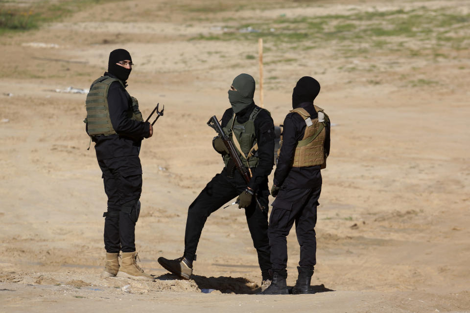 Palestinian militants stand guard during a military drill organized by military factions outside Gaza City, Tuesday, Dec. 29, 2020. Palestinian militants in the Gaza Strip fired a salvo of rockets into the Mediterranean Sea on Tuesday as part of a self-styled military drill aimed at preparing for a possible war with Israel. (AP Photo/Adel Hana)