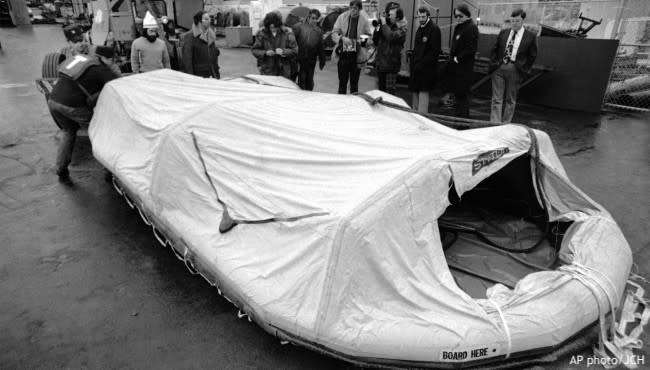 In a Nov. 11, 1975 photo, two U.S. Coast Guardsmen move a life raft from the freighter Edmund Fitzgerald across the dock in Sault Ste. Marie, Mich., after the raft was plucked from Whitefish Bay by the freighter Roger Blough, a ship assisting in…