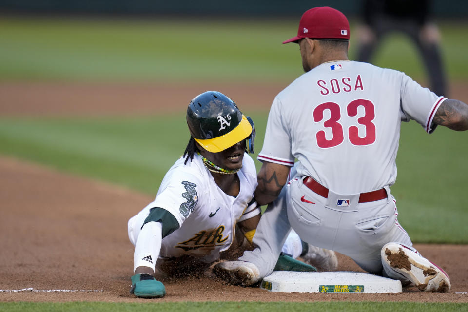 Oakland Athletics' Esteury Ruiz, left, steals third base next to Philadelphia Phillies third baseman Edmundo Sosa (33) during the sixth inning of a baseball game in Oakland, Calif., Friday, June 16, 2023. (AP Photo/Godofredo A. Vásquez)