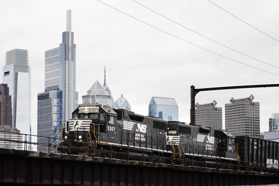 FILE - A Norfolk Southern freight train moves along elevated tracks in Philadelphia, Wednesday, Oct. 27, 2021. Railroads will be required to maintain two-person crews under a new rule announced Wednesday, July 27, 2022, that will thwart the industry’s efforts to cut crews down to one person. (AP Photo/Matt Rourke)