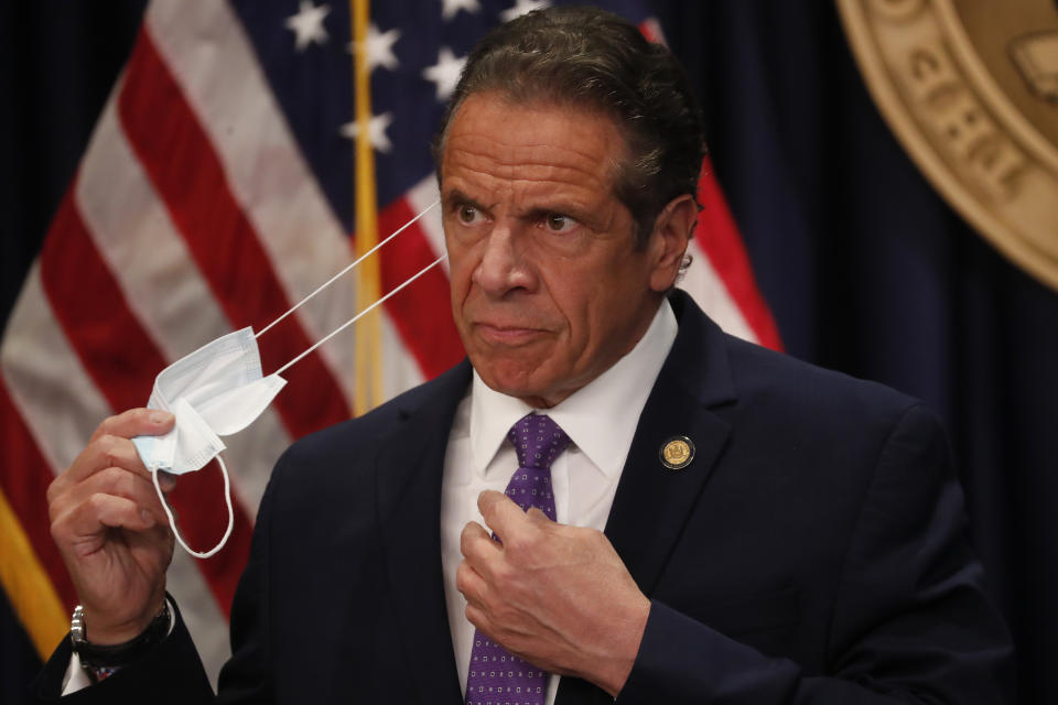 Gov. Andrew Cuomo takes off his face mask before a news conference in New York on Monday, April 19, 2021. New York’s comptroller has asked the state attorney general’s office to launch a criminal investigation into whether the governor used state resources to write and promote his book on leadership in the COVID-19 pandemic. (Shannon Stapleton/Pool via AP)