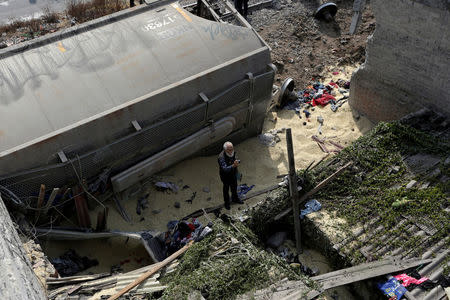 A man takes pictures of the damaged left by the car of a cargo train that ran off the tracks knocking a home in the municipality of Ecatepec, on the outskirts of Mexico City, Mexico January 18, 2018. REUTERS/Daniel Becerril