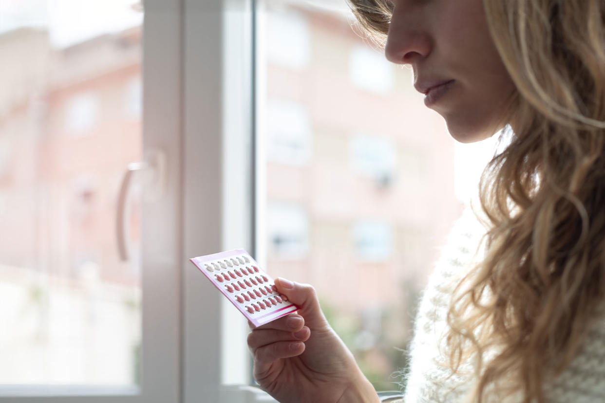 Young woman holding contraceptive pills Getty Images/Cris Cantón