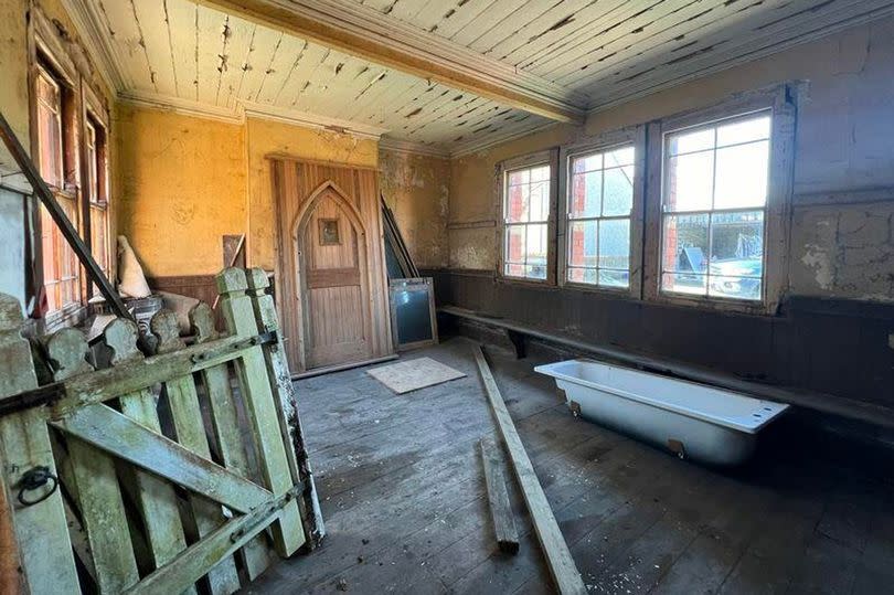 The main waiting room with wooden benches and stored station paraphernalia