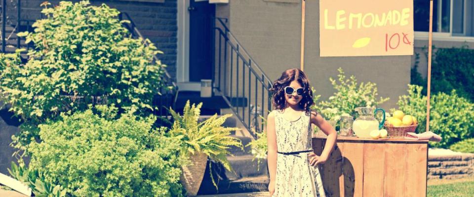 retro girl wearing sunglasses with lemonade stand