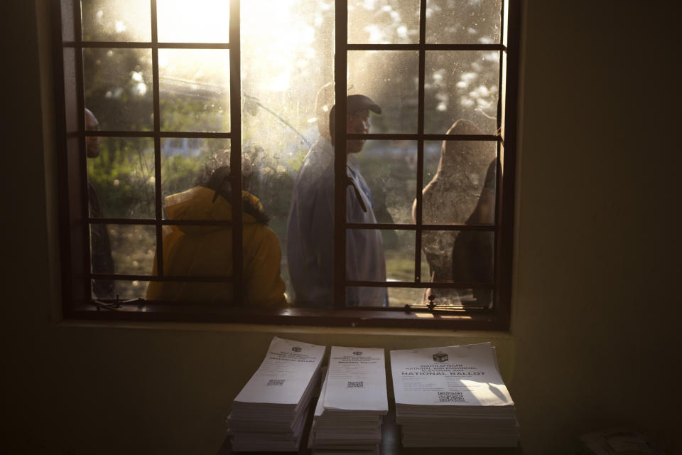 Voters wait outside a poling station on Wednesday May 29, 2024, during general elections in KwaMfana, South Africa. South Africans are voting in an election seen as their country's most important in 30 years, and one that could put them in unknown territory in the short history of their democracy, the three-decade dominance of the African National Congress party being the target of a new generation of discontent in a country of 62 million people — half of whom are estimated to be living in poverty. (AP Photo/Emilio Morenatti)