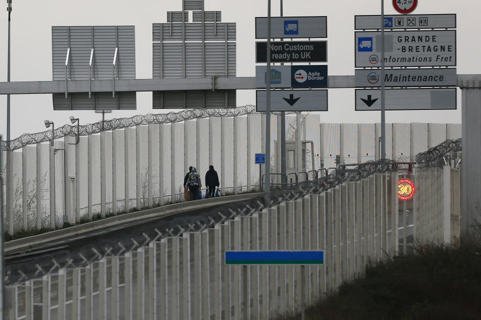 Migrants walk toward the check point on the Eurotunnel site in Coquelles, Monday Jan.4, 2021. Britain left the European bloc's vast single market for people, goods and services, completing the biggest single economic change the country has experienced since World War II. (AP Photo/Michel Spingler)
