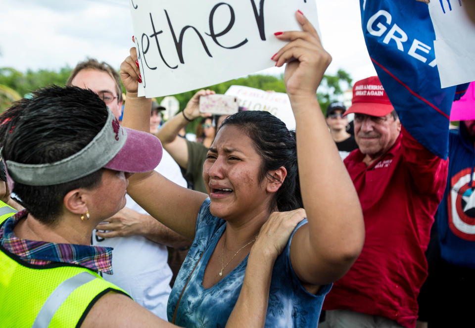 A demonstrator holding a sign confronts pro-Trump supporters during the “Keep Families Together” march outside the Homestead temporary shelter for unaccompanied migrant children in Homestead, Fla., on June 23, 2018. (Photo: Saul Martinez/Bloomberg via Getty Images)