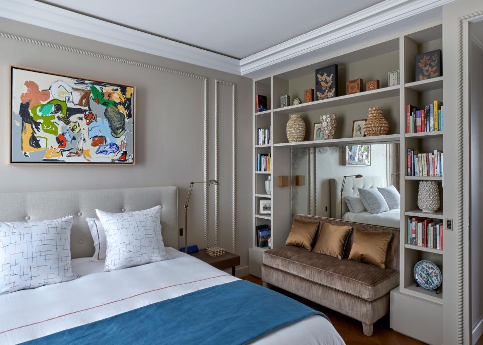 The cheerful guest room is right off the kitchen and features custom bedding and upholstery in Hermès and Rubelli fabrics. The bookshelves are stacked with Paris-themed books and objects. Above the bed hangs a painting found at FIAC, the annual contemporary art fair in Paris, by American artist Eddie Martinez.