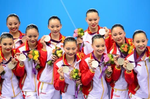 China's team celebrate on the podium after winning silver in the team free routine final during the synchronised swimming competition at the London 2012 Olympic Games, on August 10, in London