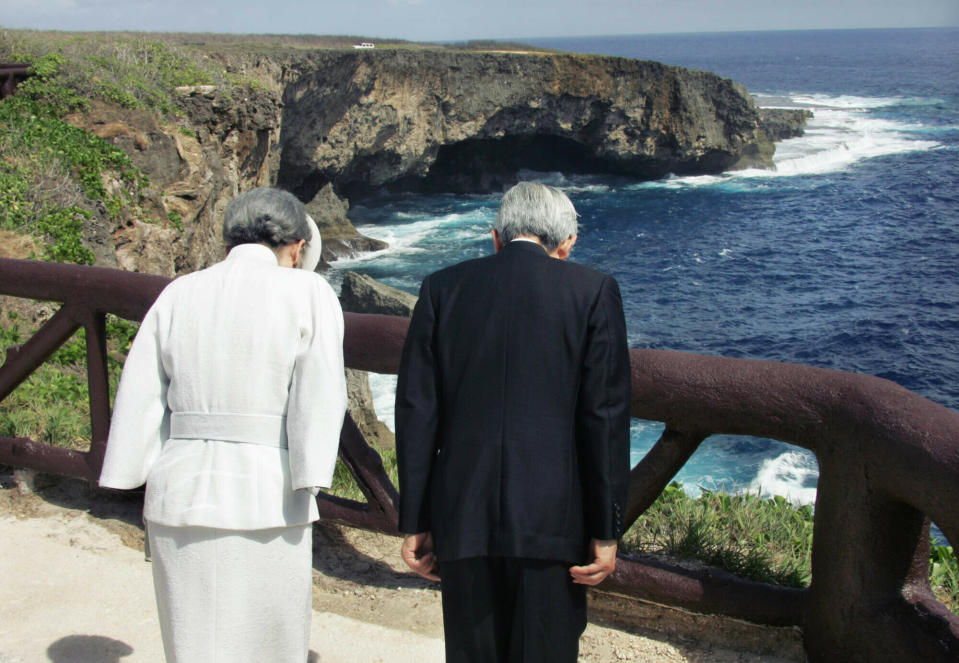 FILE - In this June 28, 2005, file photo, Emperor Akihito, right, accompanied by Empress Michiko bow to the infamous Banzai Cliff, or Puntan Sabaneta, in Saipan, to offer prayers for the Japanese soldiers and civilians who jumped off the rocky cliff 60 years ago to avoid being captured by the U.S forces in the bloody World War Two Battle of Saipan. Akihito has visited World War II battle sites, including Okinawa and the Pacific island of Saipan, and prayed for the dead on both sides, repeatedly expressing remorse for Japan’s past military aggression. (Eriko Sugita/U.S. Pool Photo via AP, File)