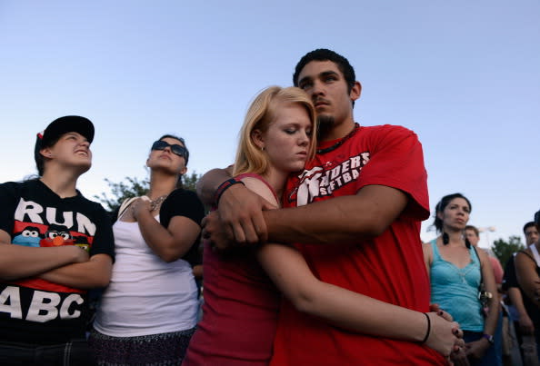 Lonnie Delgado (R) hugs Heaven Leek during a prayer for victims at the Century 16 movie theatre where a gunman attacked movie goers during an early morning screening of the new Batman movie, 'The Dark Knight Rises' on July 20, 2012 in Aurora, outside of Denver, Colorado. According to reports, 12 people were killed and 59 wounded when James Holmes allegedly opened fire inside the theater. Police have Holmes 24, of North Aurora, in custody. (Photo by Kevork Djansezian/Getty Images)