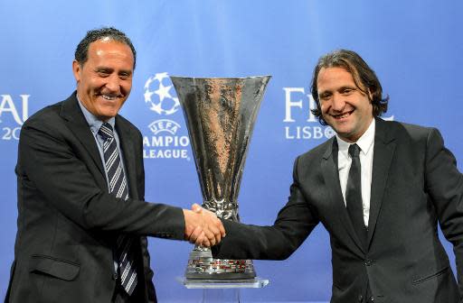 Francisco López Alfaro, representante del Sevilla (izq), y Francisco Rufete, del Valencia, se dan la mano ante el trofeo de la Europa League este viernes 11 de abril en Nyon (Suiza), tras el sorteo de las semifinales (AFP | Fabrice Coffrini)