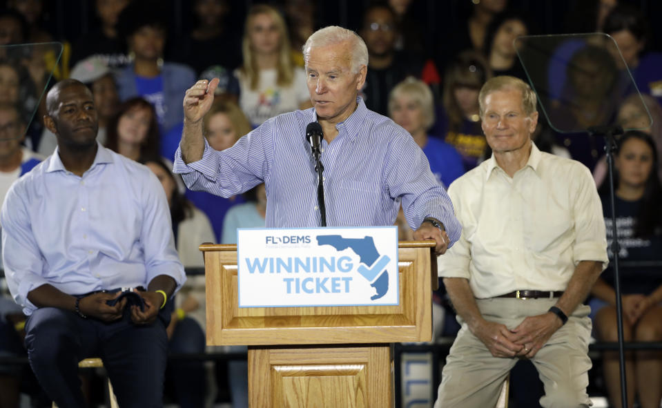 In this Oct. 22, 2018 photo former Vice President Joe Biden speaks during a campaign rally for Florida Democratic gubernatorial candidate Andrew Gillum, left, and U.S. Sen. Bill Nelson, D-Fla., at the University of South Florida in Tampa, Fla. In the past, Florida's top races were tug-of-wars over taxes and education and insurance. This time around the governor's race is a proxy battle between President Donald Trump, who brought GOP gubernatorial nominee Ron DeSantis to prominence, and Democrats who oppose him. (AP Photo/Chris O'Meara)