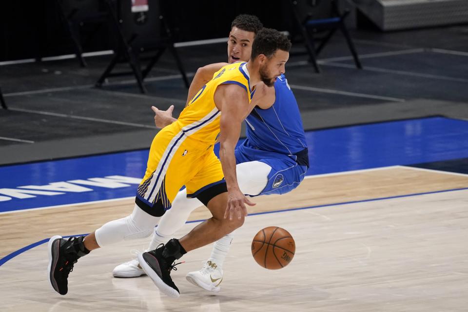 Golden State Warriors guard Stephen Curry (30) drives past Dallas Mavericks' Dwight Powell on his way to the basket during the first half of an NBA basketball game in Dallas, Thursday, Feb. 4, 2021. (AP Photo/Tony Gutierrez)