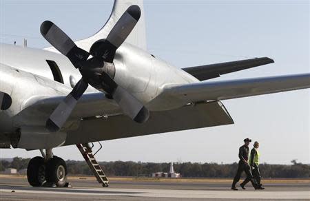 The flight crew from a Royal Australian Air Force (RAAF) P-3 Orion aircraft step off the plane after it returned from a search of Malaysian Airlines flight MH370 in the Indian Ocean, at RAAF Base Pearce north of Perth, March 21, 2014. REUTERS/Jason Reed