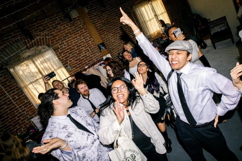 A photo of Taylor Swift fans dancing to her music at a listening party.