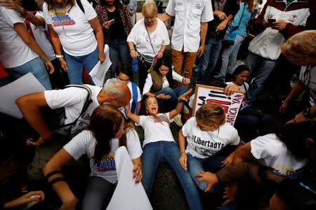 Lilian Tintori (C), wife of jailed Venezuelan opposition leader Leopoldo Lopez, shouts while she lies on the ground next to supporters, during a gathering outside the Organization of American States (OAS) headquarters in Caracas, Venezuela June 23, 2016. REUTERS/Mariana Bazo TPX IMAGES OF THE DAY