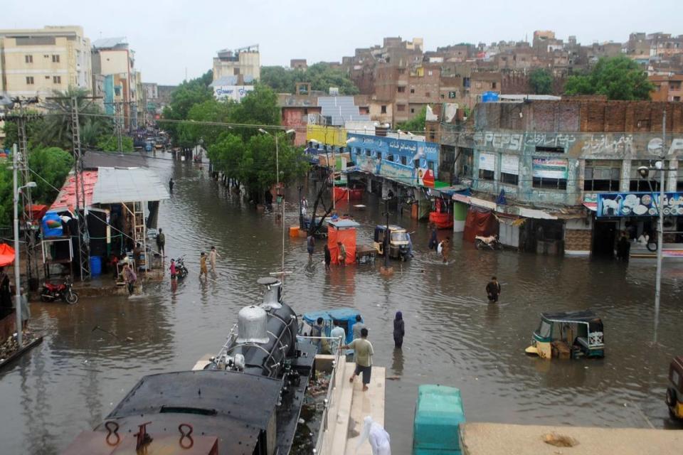 People navigate through flooded roads after heavy monsoon rains, in Hyderabad, Pakistan, Wednesday, Aug. 24, 2022.