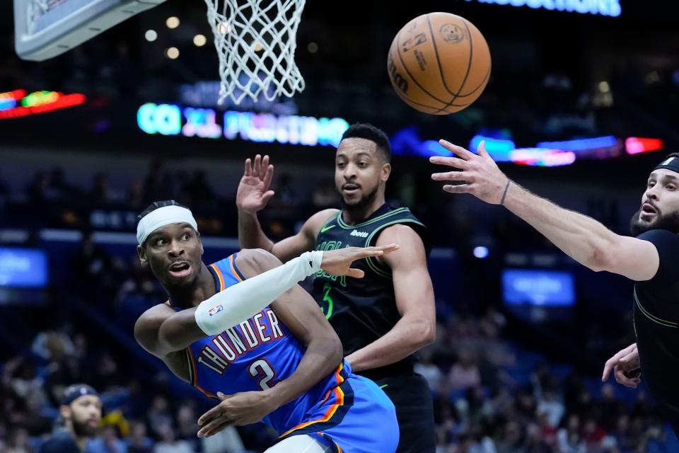 Thunder guard Shai Gilgeous-Alexander (2) passes around Pelicans guard CJ McCollum (3) and forward Larry Nance Jr. in the second half of a 107-83 win Friday night in New Orleans.