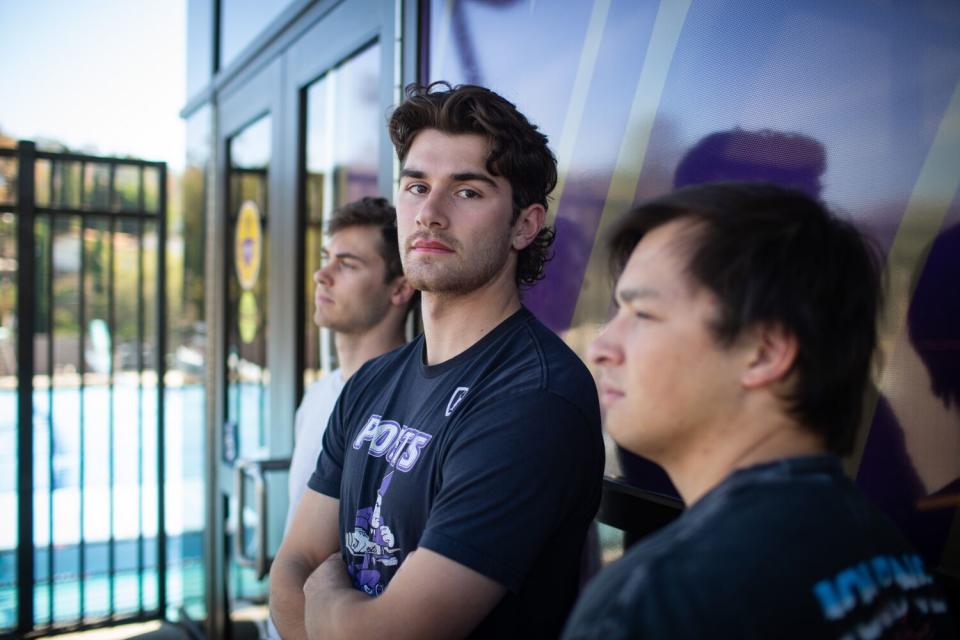 Whitter College athletes stand with folded arms.