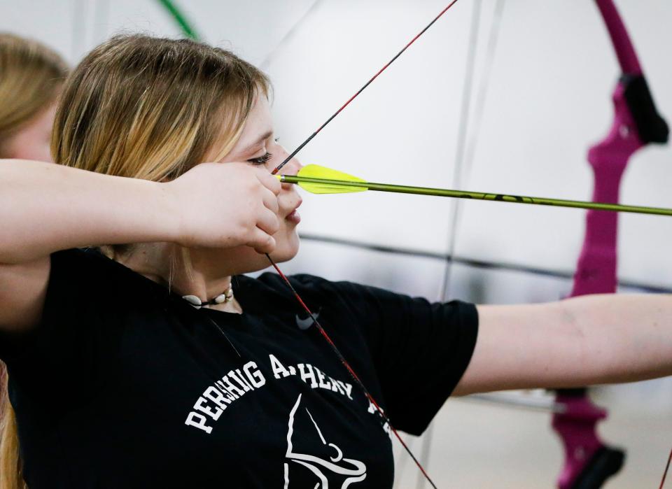 Kinsley Hilton, a sixth grader at Pershing Middle School, readies her bow and arrow as she competes during a state-qualifying archery tournament at the Ozark Empire Fair Grounds Central Building on Wednesday, Jan. 31, 2024.