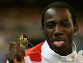 MELBOURNE, AUSTRALIA - MARCH 25: Phillips Idowu of England poses for a picture during the medal ceremony for the men's Triple Jump at the athletics during day ten of the Melbourne 2006 Commonwealth Games at the Melbourne Cricket Ground on March 25, 2006 in Melbourne, Australia. Phillips Idowu of England won gold, Khotso Mokoena of South Africa won silver and Alwyn Jones of Australia won bronze. (Photo by Mike Hewitt/Getty Images)