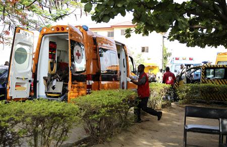 A Red Cross worker runs towards an ambulance carrying victims of a bomb blast at the Asokoro General Hospital in Abuja April 14, 2014. REUTERS/Afolabi Sotunde