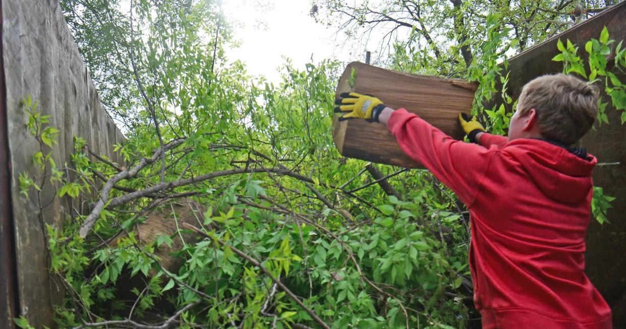 A volunteer loads tree debris into a large trash skip during a previous Spring Spruce-up in Salina.