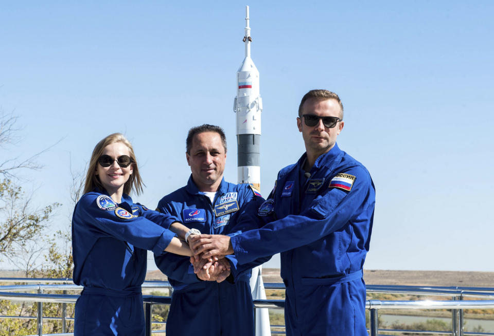 In this handout photo released by Roscosmos, Actress Yulia Peresild, left, director Klim Shipenko' right, and cosmonaut Anton Shkaplerov, members of the prime crew of Soyuz MS-19 spaceship pose at the Russian launch facility in the Baikonur Cosmodrome, Kazakhstan, Monday, Sept. 27, 2021. PIn a historic first, Russia is set to launch an actress and a film director to space to make a feature film in orbit. Actress Yulia Peresild and director Klim Shipenko are set to blast off Tuesday for the International Space Station in a Russian Soyuz spacecraft together with Anton Shkaplerov, a veteran of three space missions. (Andrey Shelepin, Roscosmos Space Agency via AP)