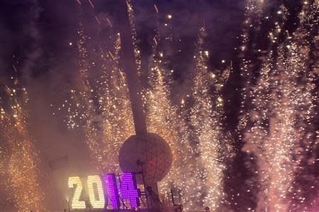 Fireworks explode past the Times Square Ball after it dropped to signal the start of the new year in Times Square, Midtown, New York January 1, 2014. REUTERS/Adrees Latif