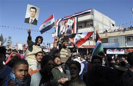 Supporters of Syria's President Bashar al-Assad attend a rally in support of Assad and the army at Ghzlaniah town near Damascus February 8, 2014, in this handout photograph released by Syria's national news agency SANA. REUTERS/SANA/Handout