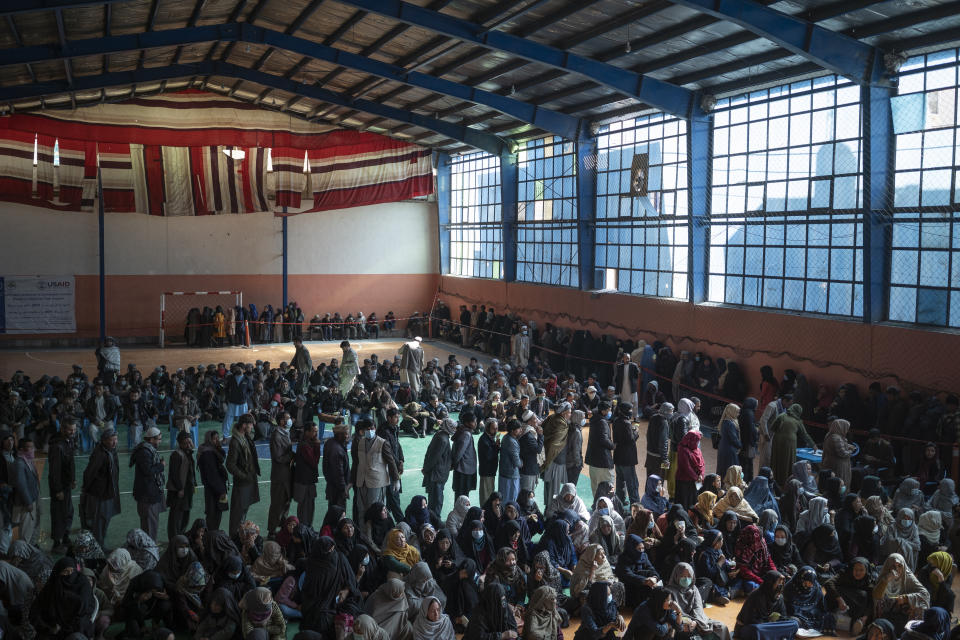 FILE - People wait in lines to receive cash at a money distribution organized by the World Food Program (WFP) in Kabul, Afghanistan, Wednesday, Nov. 3, 2021. UN World Food Program top official Mary-Ellen McGroarty says Afghanistan is facing a "tsunami of hunger," with the country on the verge of economic collapse and more than half of the population struggling to eat this winter. In an interview with The Associated Press on Thursday, Jan. 13, 2022 the WFP leader in Afghanistan urged the international community to separate political discussions from the humanitarian imperative by making sure the billions in aid that are required to avoid a disaster keep reaching the country, which is being run by the Taliban. (AP Photo/Bram Janssen, File)