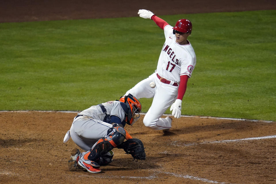 Los Angeles Angels' Shohei Ohtani (17) scores on a fielder's choice past Houston Astros catcher Martin Maldonado on a ground ball by Jared Walsh during the eighth inning of a baseball game, Monday, April 5, 2021, in Anaheim, Calif. (AP Photo/Marcio Jose Sanchez)