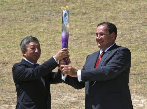 Ser Miang Ng (left) holds the Olympic flame with Spyros Capralos of Greece at a ceremony in Olympia in July 2010. (AFP File Photo)