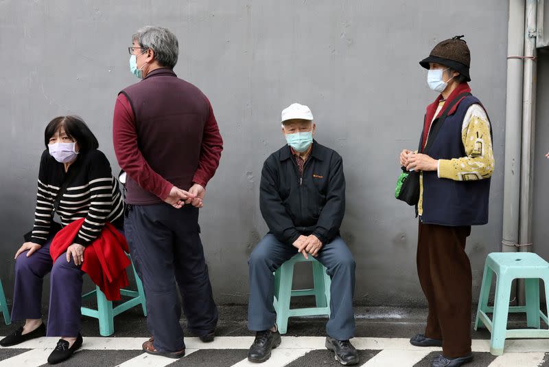 People wait in long lines to buy face masks in order to protect themselves from the coronavirus disease (COVID-19), outside a pharmacy in Taipei