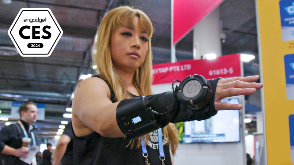 An image with a badge for Engadget Best of CES 2024 showing the product: Gyrogear GyroGlove being worn on the right forearm and wrist by Engadget editor Cherlynn Low who has her hand extended.