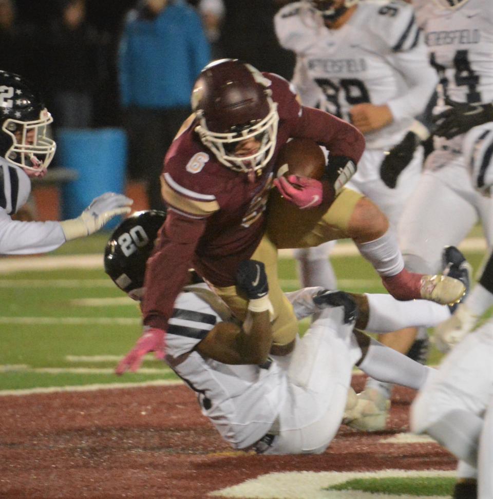 Killingly senior Ben Jax fights for a first down against Wethersfield's Dhallas Morgan. Killingly prevailed, 34-13.