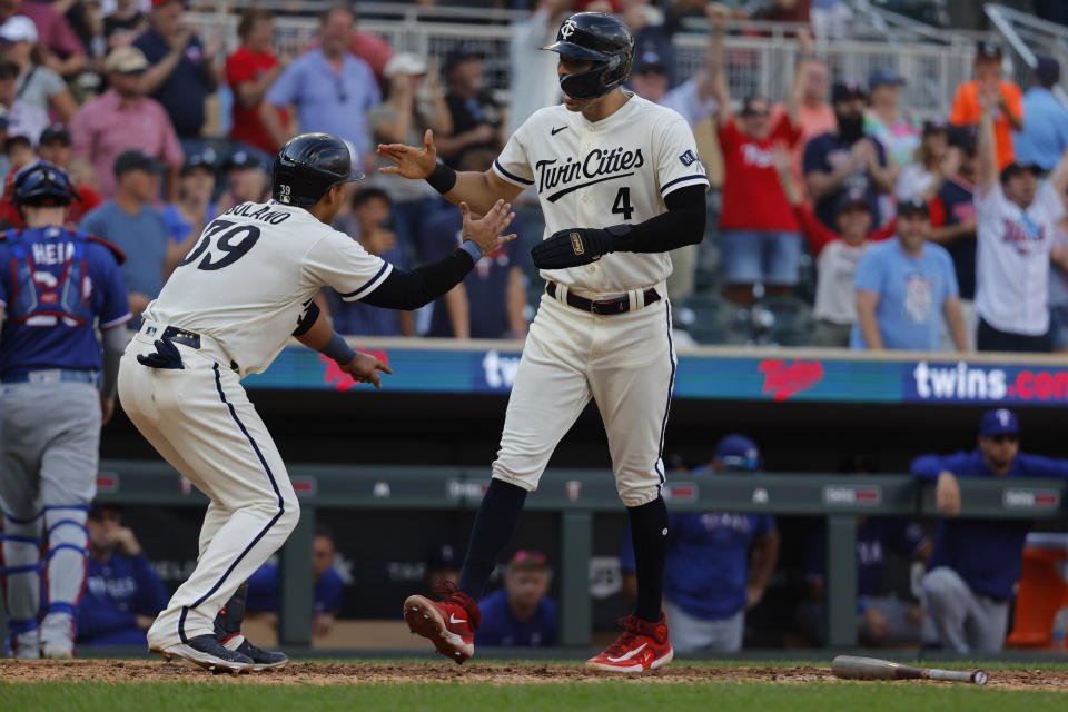 Minnesota Twins' Donovan Solano, left, greets Carlos Correa who scores the winning run on a bases-loaded walk against the Texas Rangers in the 13th inning of a baseball game Sunday, Aug. 27, 2023, in Minneapolis. The Twins won 7-6 in 13 innings. (AP Photo/Bruce Kluckhohn)