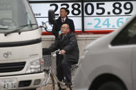 People stand by an electronic stock board of a securities firm in Tokyo, Wednesday, Dec. 25, 2019. Chinese and Japanese stocks declined Wednesday while most other Asian markets were closed for Christmas Day.(AP Photo/Koji Sasahara)